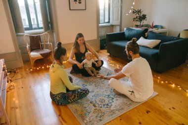 Huzurlu ve huzurlu bir aile birlikteliği ve farkındalık anı samimi, davetkar, aydınlık bir oturma odasında paylaşılır.