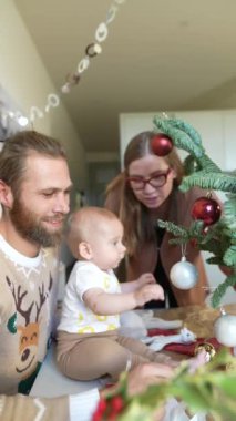 Noel 'i kutlamanın özünü yakalayan neşeli bir aile anı. Güzel süslemeler ve bir bebekle dolu.