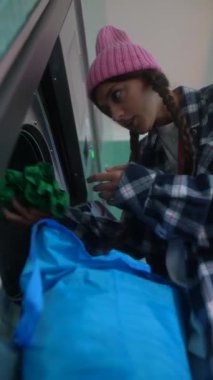 Genç bir kadın rengarenk çamaşırlarını düzenliyor, gündelik tarzını canlı ve canlı bir şekilde ön plana çıkarıyor.