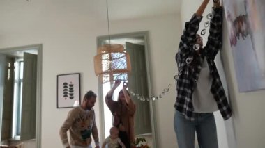 Arkadaşlar neşeli bir şekilde modern evlerini canlı çelenklerle süslerler. Parlak, davetkar bir yaşam alanı.