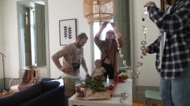 Bir aile, sevgi dolu sıcak ve rahat yaşam alanlarında neşeyle renkli dekorasyonlar hazırlıyor.