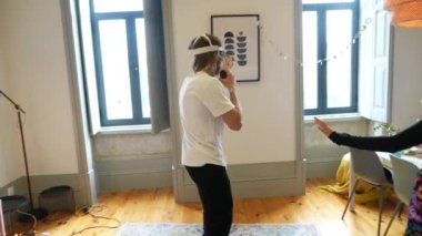 Çağdaş dekorun yer aldığı şık bir odada kendini tamamen sanal gerçekliğe kaptırmış bir birey.