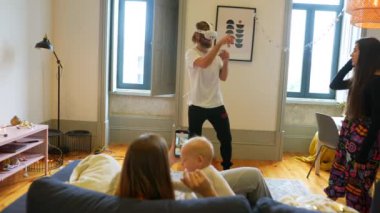 Şık bir oturma odasında sıcak bir aile buluşmasında bir yetişkin ve çocuk birlikte neşeli anılar yaratıyor.