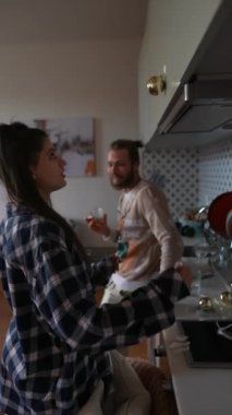 İki mutlu birey, şık ve modern bir mutfak atmosferinde rahat bir yemek pişirme seansının keyfini çıkarıyorlar.