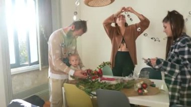 Renkli süslemelerle çevrili şirin bir bebeğin yer aldığı neşeli bir aile toplantısı. Sevgi ve beraberlik gösterisi.