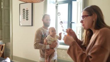 Ebeveynler ve bebekleri arasında paylaşılan sıcak bir aile anı şık bir evde kalıcı anılar yaratıyor..