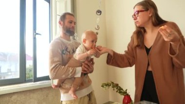 Sevgi dolu bir aile anı. Aileler sevimli bebekleriyle keyifle oynuyorlar. Sıcak, kapalı bir ortamda.