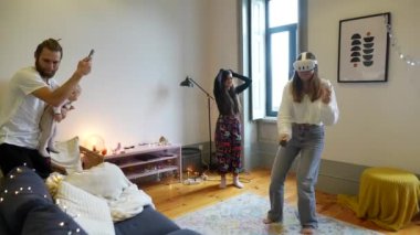 Konforlu, parlak ve davetkar bir oturma odasında VR oyunlarıyla meşgul bir aileyi canlandıran canlı bir sahne.