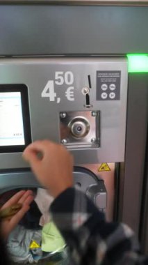 Bir çamaşırhanede modern bir çamaşır makinesi ödeme terminalinin detaylı yakın çekim görüntüsü.
