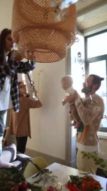 Neşeli bir aile tatil için rahat evlerini dekore eder. Birlikte sıcak ve yaratıcı anları yakalar.