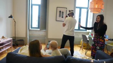 Sevgi dolu bir aile, neşe ve kahkahayla dolu sıcak ve davetkar bir oturma odasında birlikte eğlenceli anların tadını çıkarır.