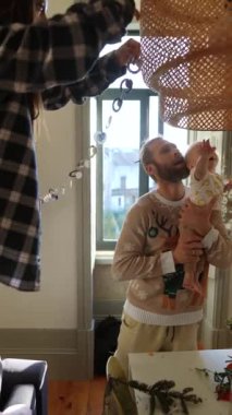 Neşeli bir aile, sıcak evlerini bir bebekle süslüyor, birlikteliklerini kutluyor ve sıcak bir ortam yaratıyor.