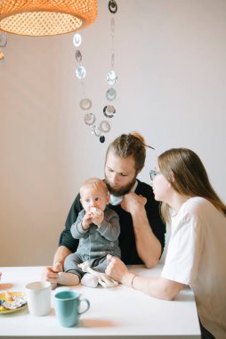 Sevgi dolu bir aile sıcak masalarında keyifli vakit geçirir, kahve ve lezzetli atıştırmalıkları paylaşır.