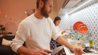 Güzel, şık bir mutfakta birlikte yemek pişiren bir çift takım çalışmalarını ve yaratıcılıklarını sergilediler.