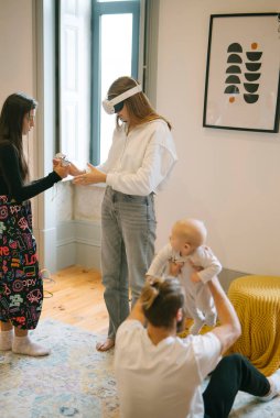 Bir aile sanal gerçeklikte kaliteli zaman geçirmenin keyfini çıkarırken aynı zamanda şık bir şekilde tasarlanmış bebekleriyle ilgilenir.