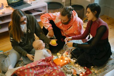 Değerli bir bebeğin etrafında sıcak bir arkadaş toplantısı, neşeli ve neşeli anları paylaşıyorlar.