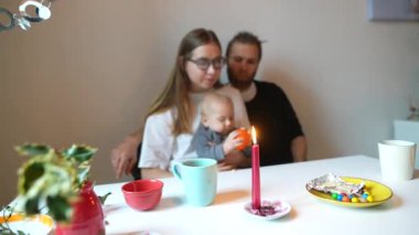 Sevgi dolu bir aile sahnesinde aileler ve bebekleri sıcak bir yemek masasında sakin bir anı kutluyorlar.