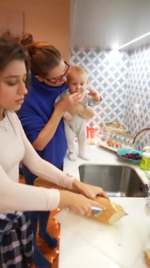 Mutfakta keyifli bir an, sevgi dolu bir aile etkileşimi ve özenli bir bebek bakımı