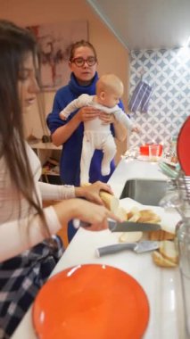 Neşeli bir mutfakta leziz yemekler pişirirken aile bağlarının sıcak bir sahnesi huzur ve mutluluk saçıyor.