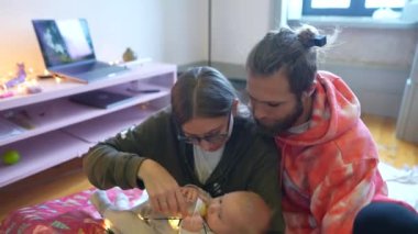 Sevecen bir ailenin samimi ve davetkar bir ortamda bebeklerini şefkatle beslediği hoş bir sahne.