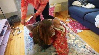 Sıcak bir iç mekan sahnesi yumuşak bir battaniyeye sarılmış bir bebekle keyifli ve eğlenceli bir anı yakalıyor.