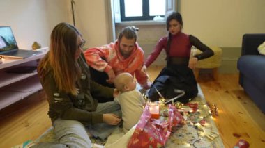 Neşeli bir aile, Noel hediyesi açılışı için dekore edilmiş oturma odalarında toplandı.