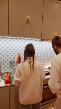 Sıcak bir mutfak ortamında, insan sıcak ve rahat bir ortam içinde neşeyle lezzetli yemekler hazırlıyor.