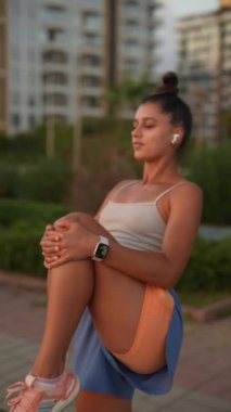 Sahilde günbatımının tadını çıkaran genç bir kadının sakin bir anı, huzur ve yansıma sergiliyor..