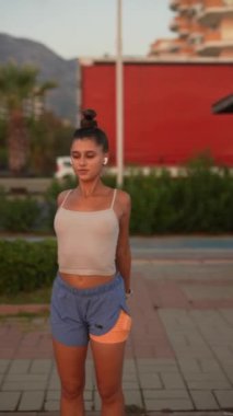 Atletik giyinen genç bir kadın gün doğumunda açık havada spor yapmayı sever, etkin bir yaşam tarzını somutlaştırır..