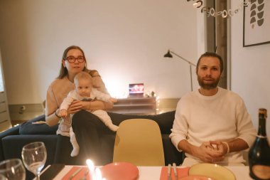 Hoş ve rahat bir aile yemeği. Bir kadın, bir erkek ve sevgili bebeklerinin birlikte eğlendiği bir gösteri.