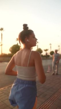 Şık kıyafetli genç bir kadın güneşli bir sokakta yürüyor, özgürlüğü ve eşsiz kişisel tarzını somutlaştırıyor.