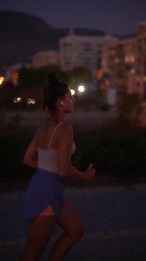 Bir kadın alacakaranlıkta koşuyor, müthiş bir şekilde zindelik, sağlık ve hareketli şehir hayatının canlı özünü gösteriyor.