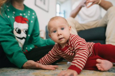 Şenlikli pijamalı bir bebek, bayram zamanı aile toplantısından zevk alır, neşe ve sıcaklık saçar..