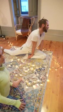 Katılımcılar, sakin ve hafif ışıklandırılmış bir ortamda aktif olarak meditasyon pratiğine katılıyorlar.