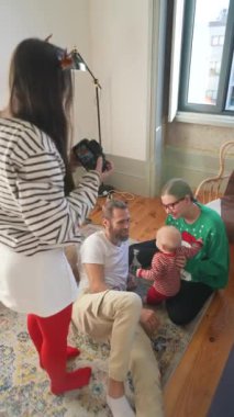 Gülümseyen bir bebekle aile toplantısı, sevgi gösterisi ve birlikteliğin sıcak şenlik ruhu.