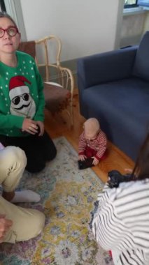 Mutlu bir aile, sıcak bir oturma odasında yumuşak bir halının üzerinde bir çocukla sıcak etkileşime girer ve neşeli anılar yaratır.