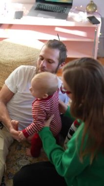 Neşeli ve neşeli bir aile sahnesi. Neşeli bayram kutlamalarında şenlikli kıyafetler giymiş bir bebek.