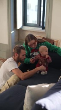 Sevimli bir aile sahnesi Kanepede sevimli bir bebek, Sevgi ve kahkaha ile bayram mevsimini kutluyor