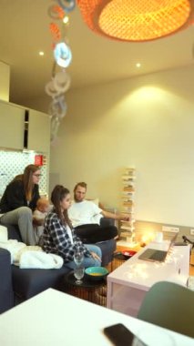 Bir grup arkadaş, eğlence ve kahkaha için modern bir yaşam alanında toplanıyor. Bağlantı ve rahatlama vurgulanıyor..