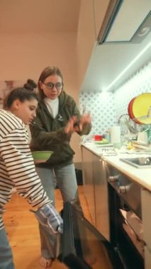 Modern bir mutfakta zevkle yemek pişiren genç bir kadının canlı bir fotoğrafı. Mutfak yaratıcılığını sergiliyor.