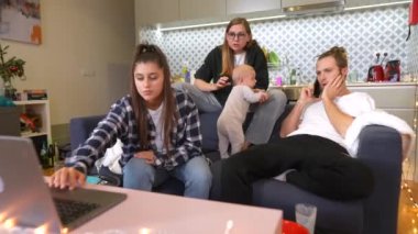 Bir grup arkadaş evlerinde rahat bir gün geçirirken bir bebek de yakınlarda bir yerde oyun oynuyor.