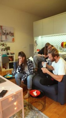 Bir grup arkadaş şık, modern bir oturma odasında rahat ve mutlu bir anın tadını çıkarıyorlar.