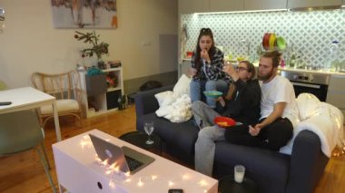 Yakın dostların sıcak ve samimi bir araya gelip şık ve modern bir oturma odasında film izlemesi.