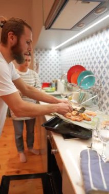 Yetenekli bir adam güzel ve modern bir mutfakta lezzetli yemekler pişirir. Olağanüstü ev yemeği teknikleri gösterir.