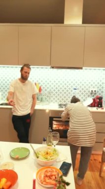 Yemek pişiren birinin olduğu bir karşılama mutfağı, canlı bir salata ve güzel bir yemek masası.