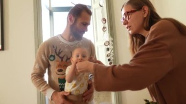 Sevgi dolu bir çift ve sevimli bebekleriyle kapalı bir ortamda neşeli ve iç açıcı bir aile anı.