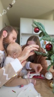 Güzel bir Noel ağacını bebekle süsledikleri için bu çok güzel bir aile anı.