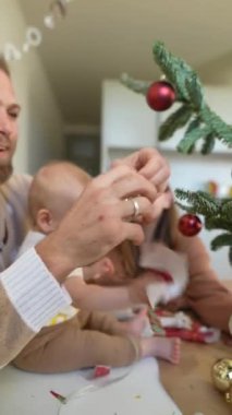 Bir ailenin Noel ağacını süslediği, sevgi ve şenlik ruhunu sergilediği yürek ısıtan bir sahne..