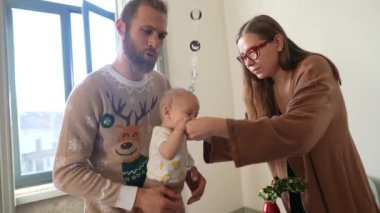 Yürek ısıtan bir aile anı sevimli bir bebek, neşeli kıyafetler içinde sevgi dolu bir ebeveyn ve sıcak bir atmosfer gösterir.