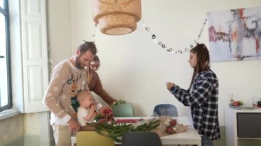 Neşeli bir grup, doğal ışıkla süslü, parlak bir odada güzel çiçek düzenlemeleri yapıyor.